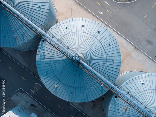 Vászonkép aerial view of blue industrial silo tops with metal structures and road