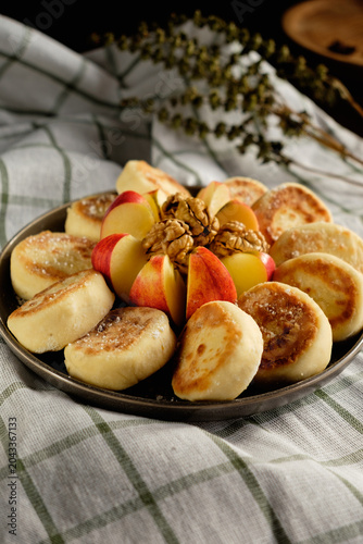Delicious Ukrainian cottage cheese pancakes served with fresh apple slices