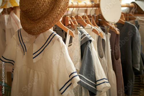 Children's clothes on hangers made of natural fabrics, calm pastel colors in an eco-friendly and retro style.