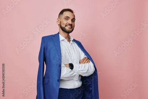 Cuadro en lienzo A confident business professional stands against a soft pink backdrop, wearing a blue suit draped over the shoulders