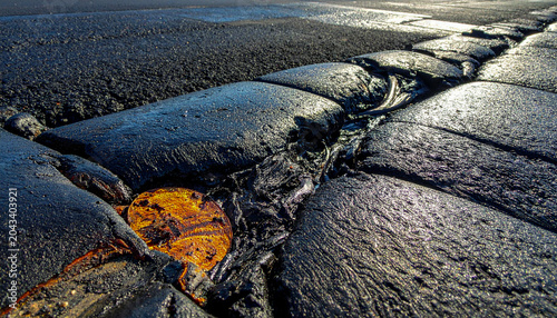 Detailed view of sticky and shiny asphalt bitumen during intense heat