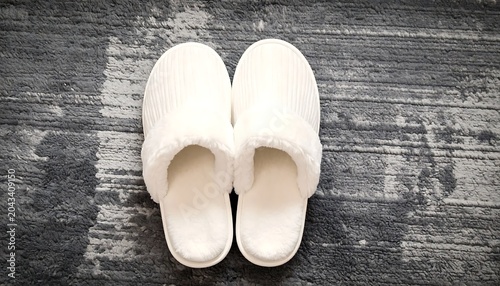 Cozy White Slippers Resting on Textured Gray Carpet Indoors