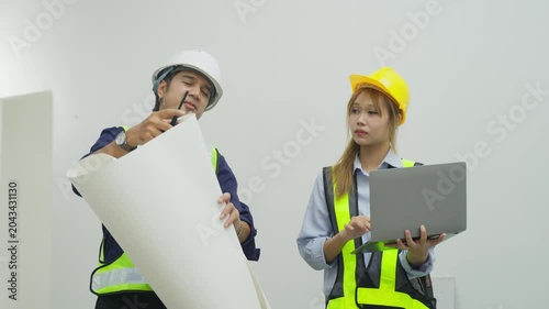 Construction worker woman hard hat safety vest laptop blueprint site planning inspection engineer project office teamwork meeting discussion review document clipboard helmet reflective vest indoor