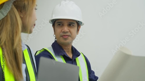 Construction worker woman safety vest helmet office discussion project engineer planning team blueprint worksite safety meeting collaboration construction worker hard hat safety vest office project