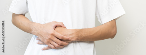Fotografija Flatulence ulcer, hurt suffer asian young man, male hand in belly, stomach pain, ache from food poisoning, abdominal and digestive problem, gastritis or diarrhoea