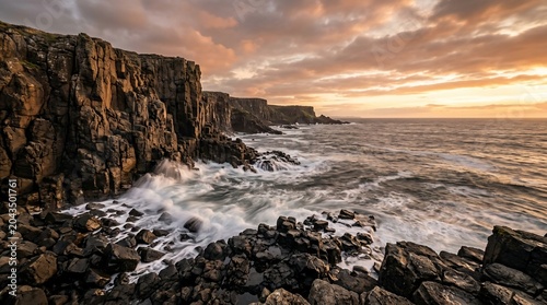 Rocky sea cliffs with crashing waves at sunset on a dramatic coastline