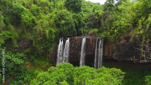 Aerial drone footage of Tad Tayicseua Waterfall, a powerful multi-tiered waterfall in Attapeu Province, southern Laos. The drone reveals the full scale of the cascading falls as water drops through de