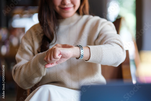 Φωτογραφία Closeup image of a woman checking time and pointing finger at a watch