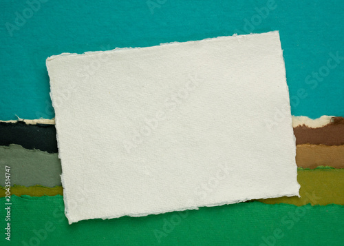 Fotografija small blank sheet of watercolor paper against abstract art paper landscape