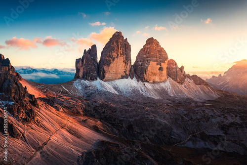 Sunset over Tre Cime di Lavaredo surrounded by alpine terrain in Dolomites, Italy