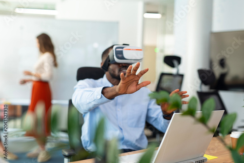 Quadro su tela Businessman experiencing virtual reality in a modern office