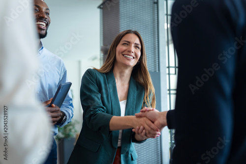 Businesswoman shaking hands with client after meeting