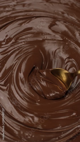 Chocolate. Melted chocolate being spread with a spoon, close up 