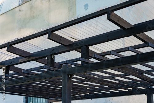 Fotografie Modern outdoor wooden pergola structure with translucent corrugated plastic roof