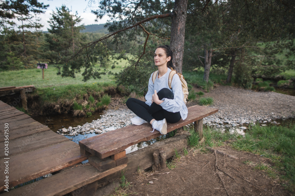 Fototapeta premium Woman relaxing on bench in nature