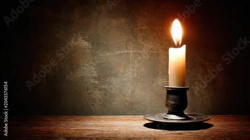 A solitary lit candle in a darkened room, casting a warm glow on a wooden surface