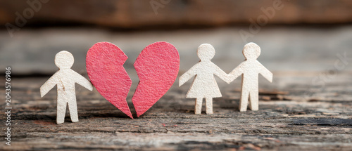 Figures stand by a broken heart on a wooden surface during a moment of reflection on relationships and emotions