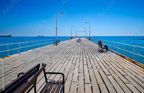 View across the famous wooden footbridge of Limasoll to the horizon under a blue sky and a blue sea, Cyprus