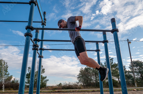 Foto Athletic Man Performing Dips Exercise on Parallel Bars in Outdoor Calisthenics P