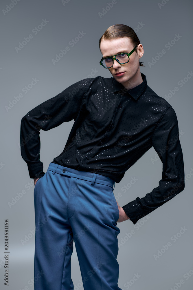 Fototapeta premium Young man showcases trendy fashion in an artistic studio portrait session