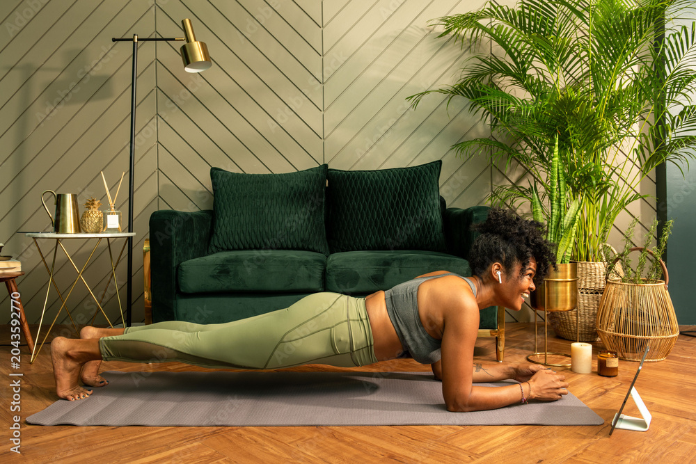 Fototapeta premium Woman doing a plank exercise in a stylish living room setting.