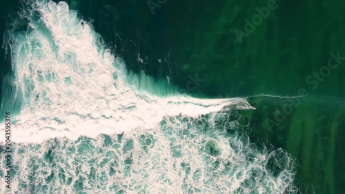 Aerial drone view of surfers, surfing paddling, duck diving, with beautiful blue collars and glass sea