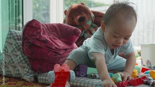 A young child is engaged in play with colorful building blocks, fostering creativity and imagination. The scene captures the joys of early childhood play in a bright and cozy environment.