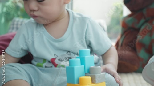 A young child engages in imaginative play by constructing with colorful building blocks. This educational activity promotes creativity and fine motor skills, creating a fun learning environment.