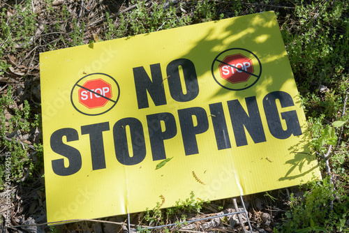 Fotografi old NO STOPPING sign discarded on the ground outdoors