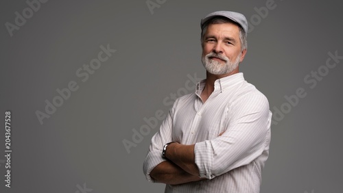 Schilderij op canvas Smiling man wearing white shirt and flat cap, close-up