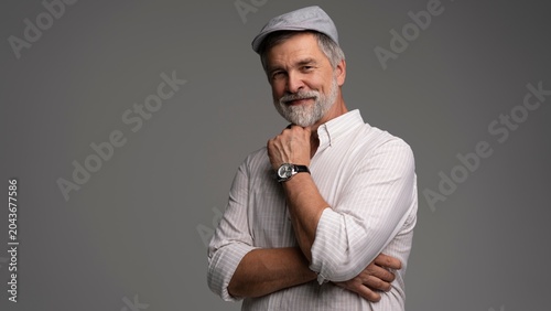 Принти на полотні Smiling man wearing white shirt and flat cap, close-up
