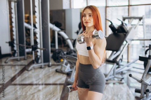 фотографія Woman performing a bicep curl with a dumbbell at the gym, staying active and foc