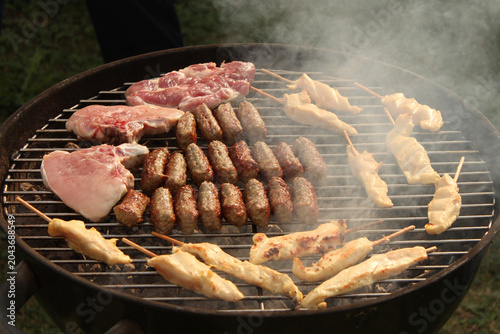 Quadro em tela charcoal grill packed with an assortment of sizzling meats, tender pork steaks,