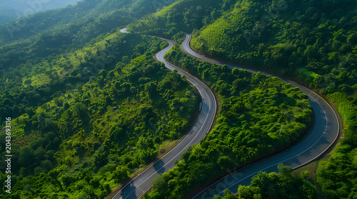 Aerial view of a winding road through a lush green tropical forest in the mountains