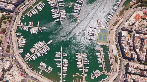 Beautiful aerial top-down view flying over marina zeas, pasalimani harbor, in piraeus, greece, showcasing luxury yachts, sailboats, and the surrounding urban cityscape on a sunny day