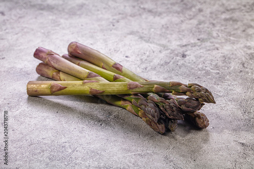 Fresh raw asparagus bunch on textured grey stone background