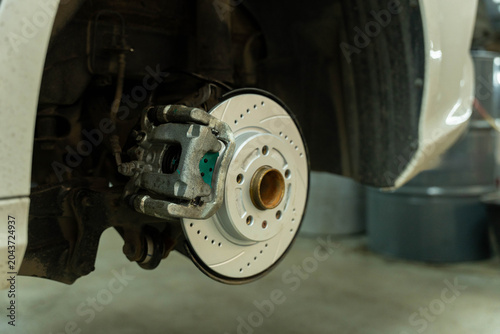 Fotografie Close up view of a vehicle wheel hub with a ventilated brake disc and caliper in