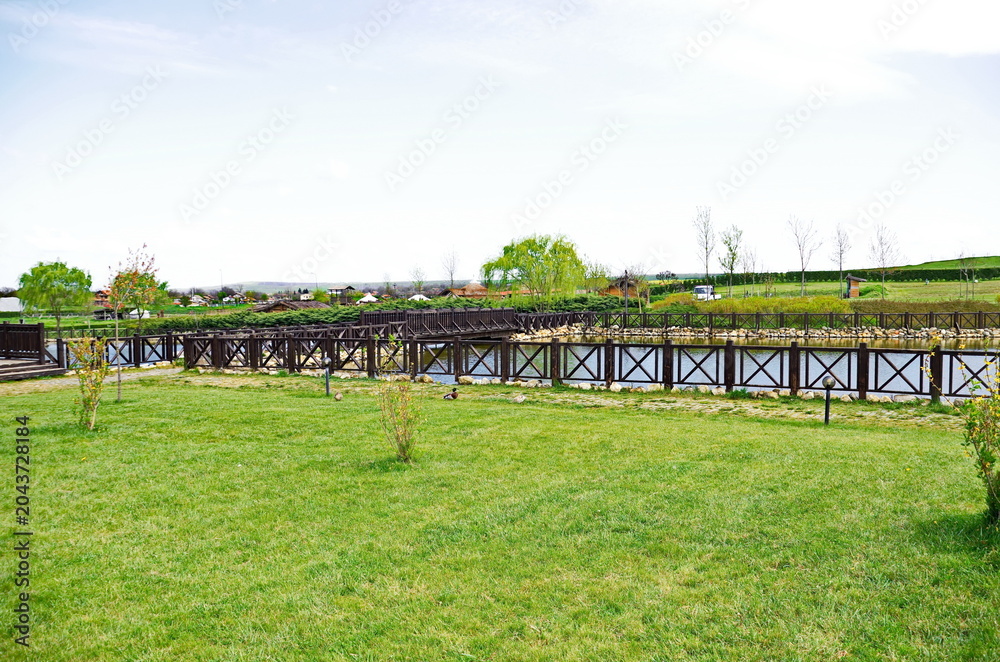 Fototapeta premium Historical park in Neofit Rilski, Bulgaria, overlooking a large lake with fences and passages, symbolically connecting the different eras of our lands 