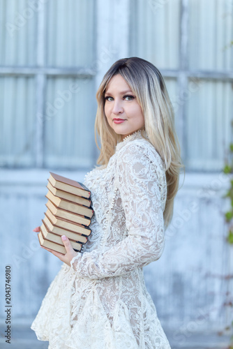 Woman Holding Stack Of Books Outdoors