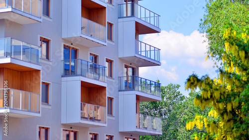 View of modern residential building with glass balconies and bright facade. Contemporary apartment building in european city. Concept of urban living and modern architecture. 