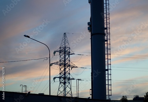 Power line and wires against the backdrop of a sunset sky beautiful summer photo urban landscape infrastructure city