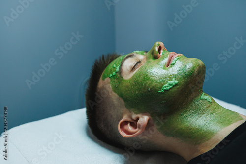 Foto Man receives a facial treatment at a cosmetology appointment in a beauty salon f