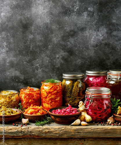 Assorted Fermented Vegetables and Pickled Foods in Glass Jars. AI generative.