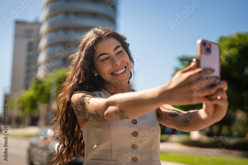 Photos Woman making selfie with smart phone in urban environment