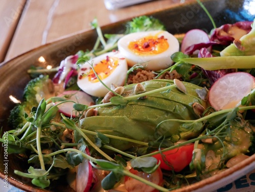 Картината върху платно Healthy Avocado Salad with Soft Boiled Eggs and Microgreens