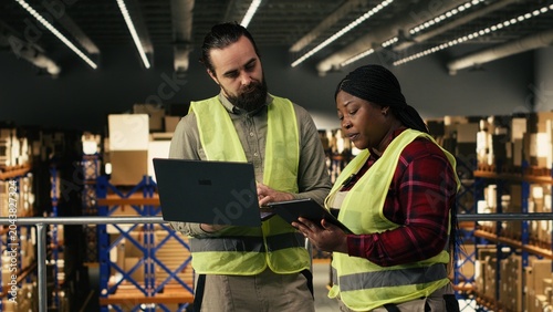 Quadro su tela Industrial job, two workers, collaborating in warehouse, parcel distribution, package handling and inventory control management, High visibility vests for operational order efficiency, Copy space