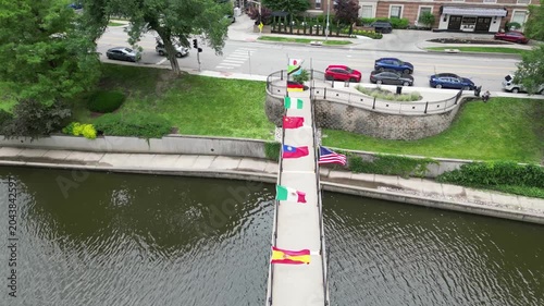 flying over flags on bridge above water