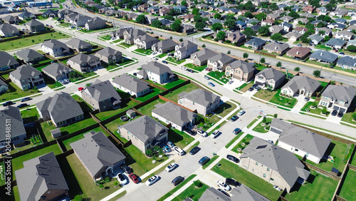 Foto Intersecting suburban blocks in Arlington, TX feature fenced yards, green lawns light colored homes arranged along clean streets with visible property boundaries