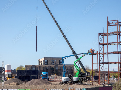 Photos Crane lifting structural steel beams for a new building construction project