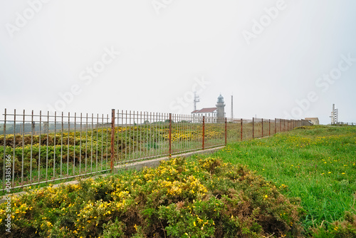 Photos Cabo de Penas lighthouse and communication buildings behind a metal fence, set a